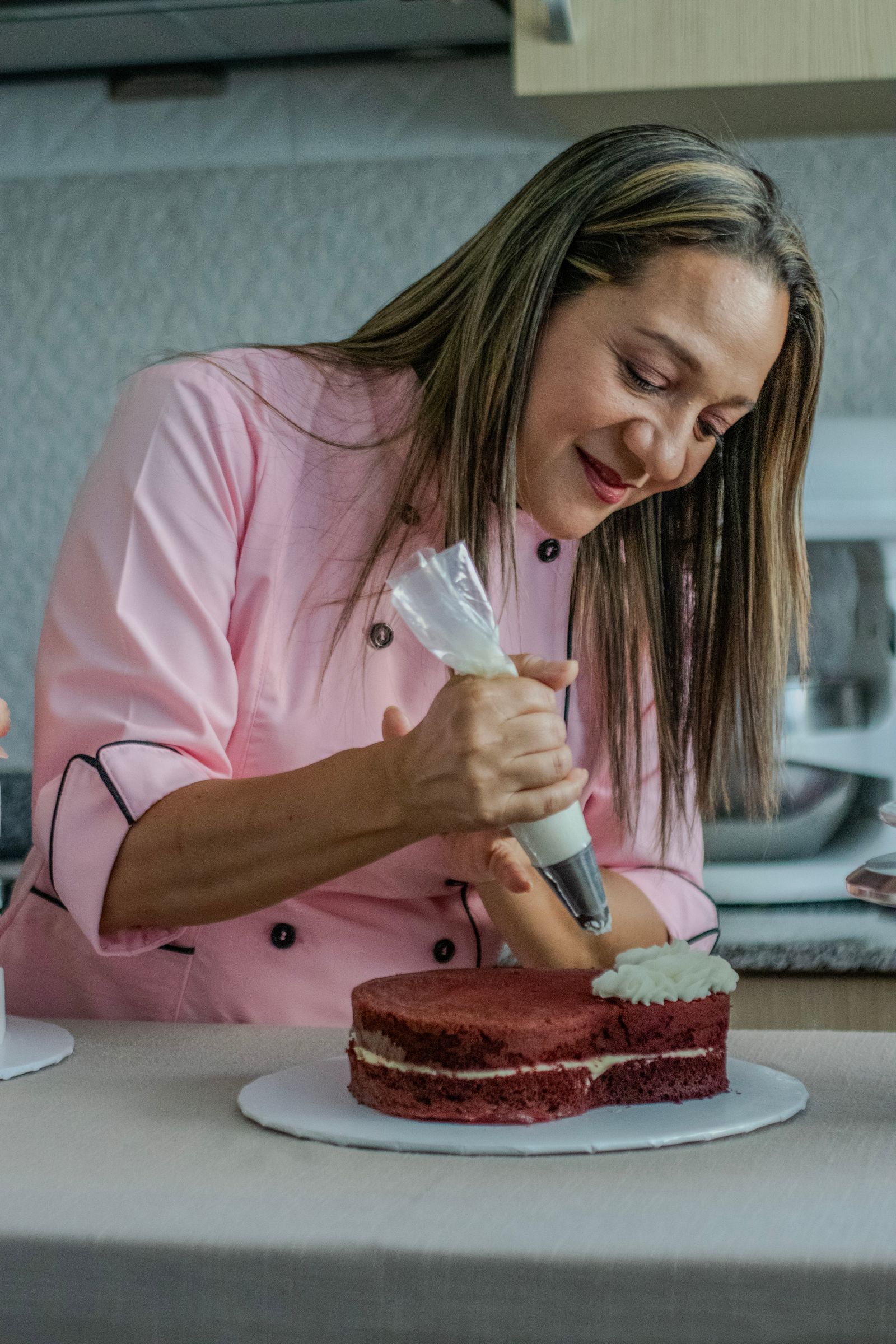 A cake professional finishing a celebration cake