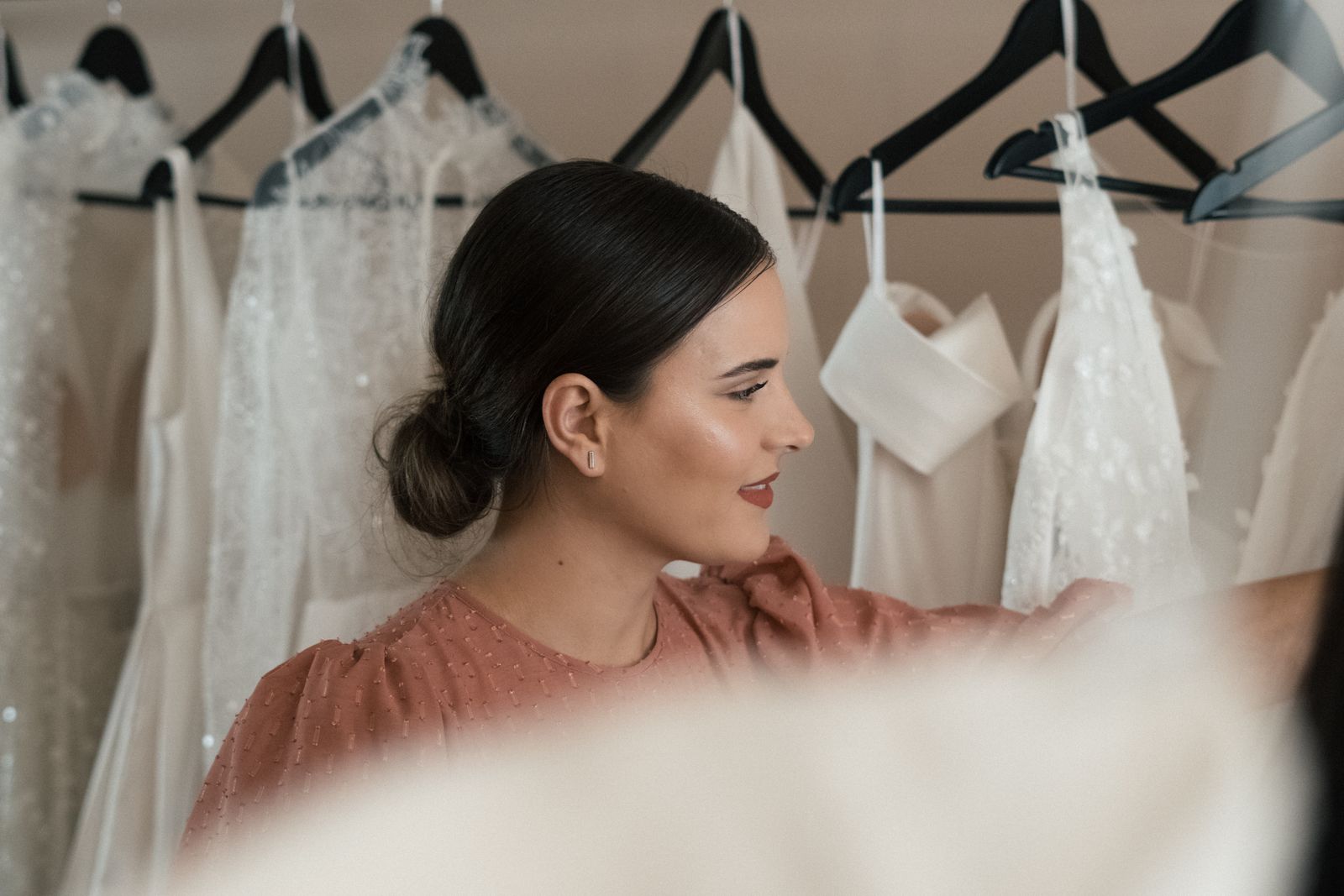 A bridal professional helping a client choose her wedding gown