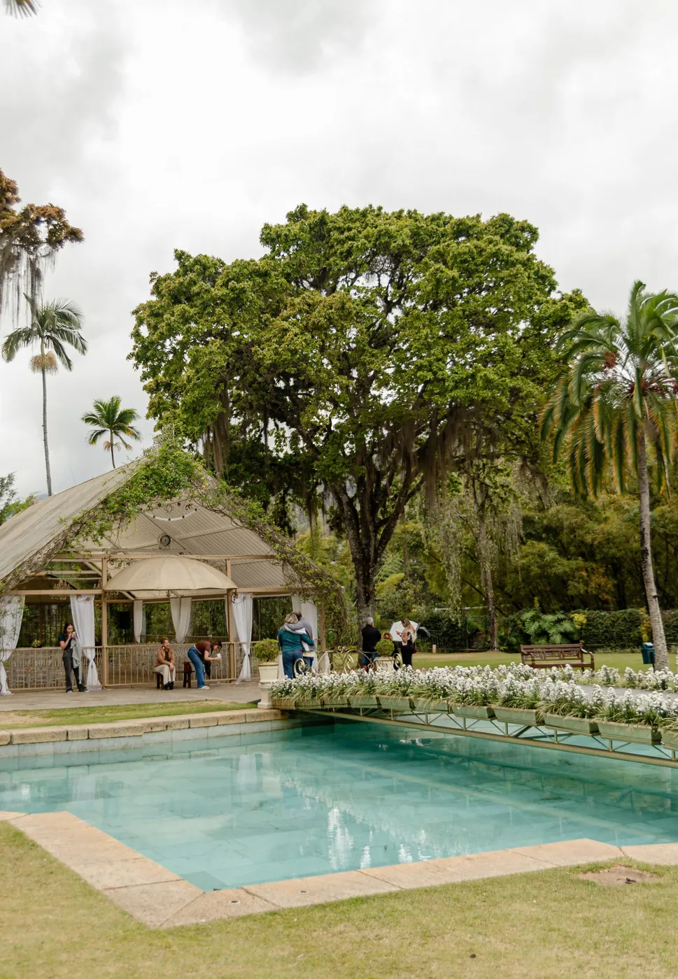 Elegant outdoor wedding venue with a serene pool surrounded by lush gardens. Licensed inspiration image; not a BMG client portfolio claim.